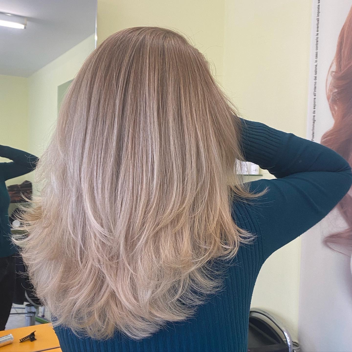 Lang, gelaagd blond haar van achteren gezien