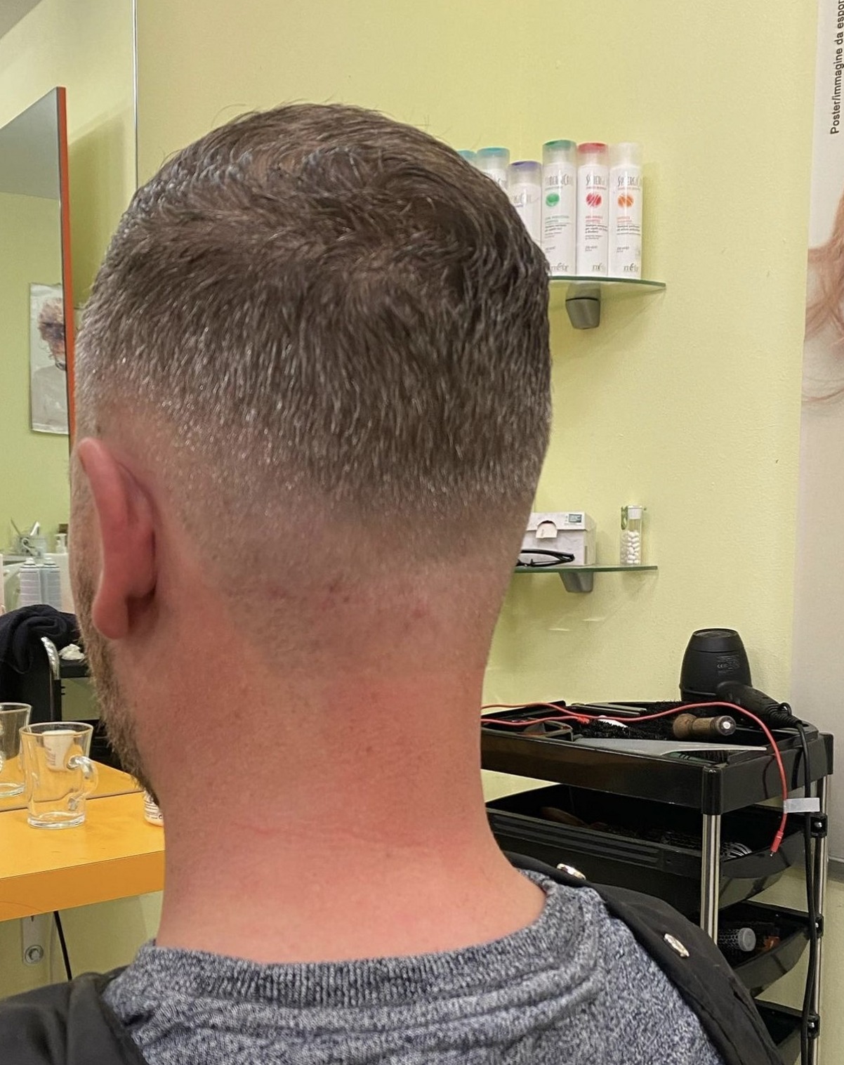 Kort herenkapsel met fade, van achteren gezien in de salon